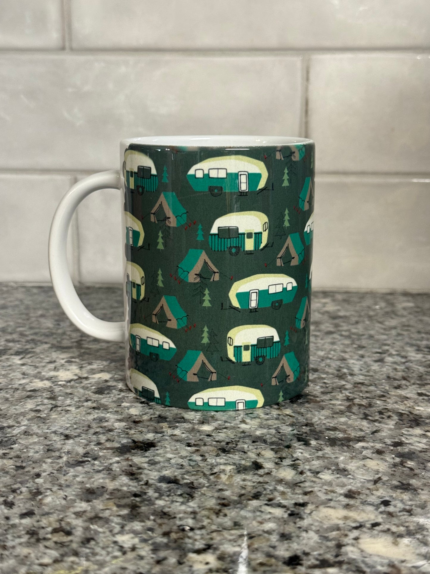 12 oz mug designed with green and white campers, trees, and tents. Part of our camper series.