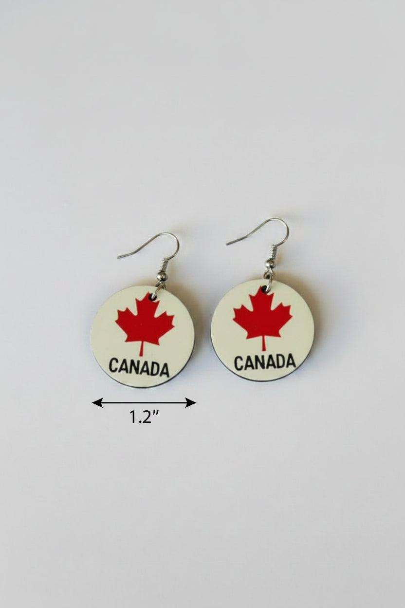 Pair of earrings with 'Canada' and red maple leaf and the word "Canada" in black at the bottom of the earrings design on a white background