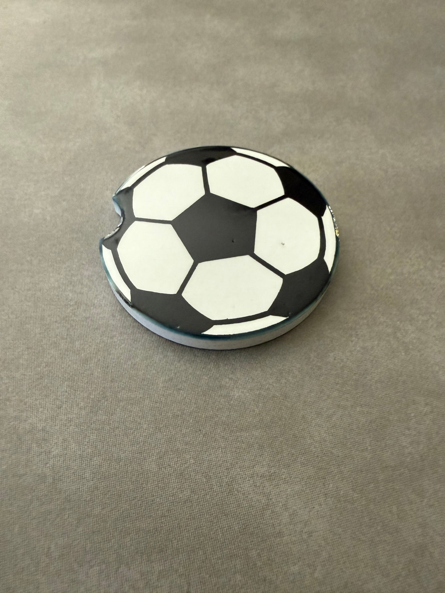 A ceramic car coaster with a soccer ball design Roxzell