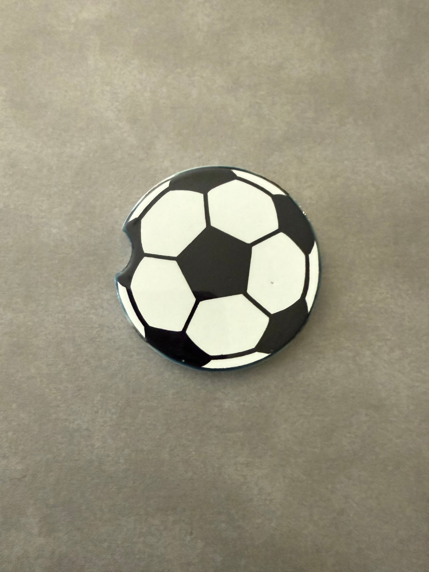 A ceramic car coaster with a soccer ball design Roxzell