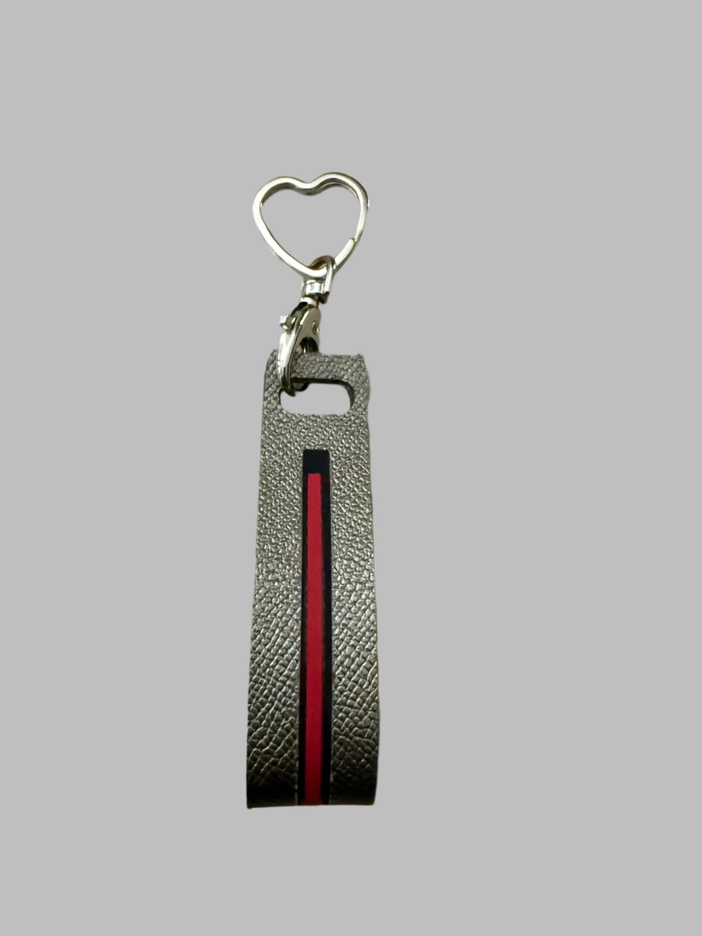 Grey leather keychain with heart shaped latch and pink stripe.