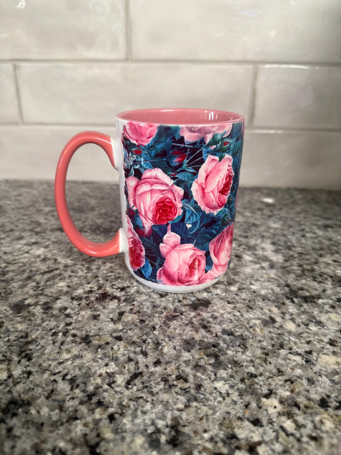 15 oz ceramic mug designed with pink and blue roses and pink handle. Mug is also pink inside.