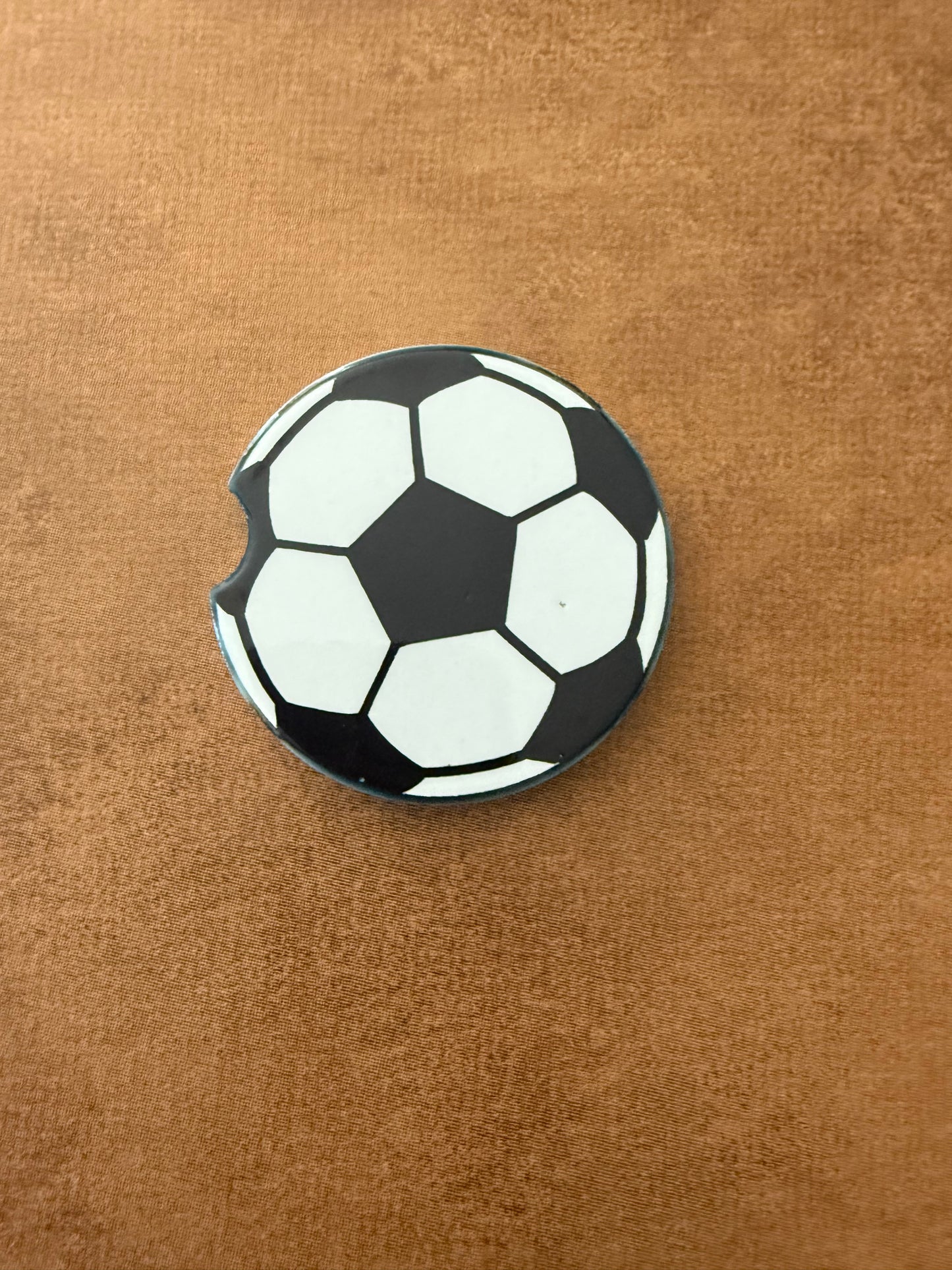 A ceramic car coaster with a soccer ball design Roxzell