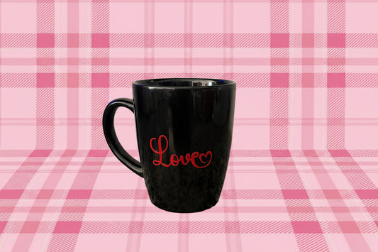 Black coffee mug with “Love” text and heart pattern on pink plaid background, Roxzell
