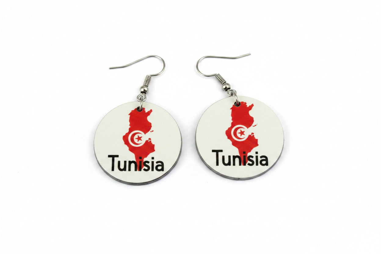Pair of round earrings featuring Tunisia’s map outline in red with a white crescent and star emblem and the word “Tunisia” printed below, displayed on a white surface. Roxzell