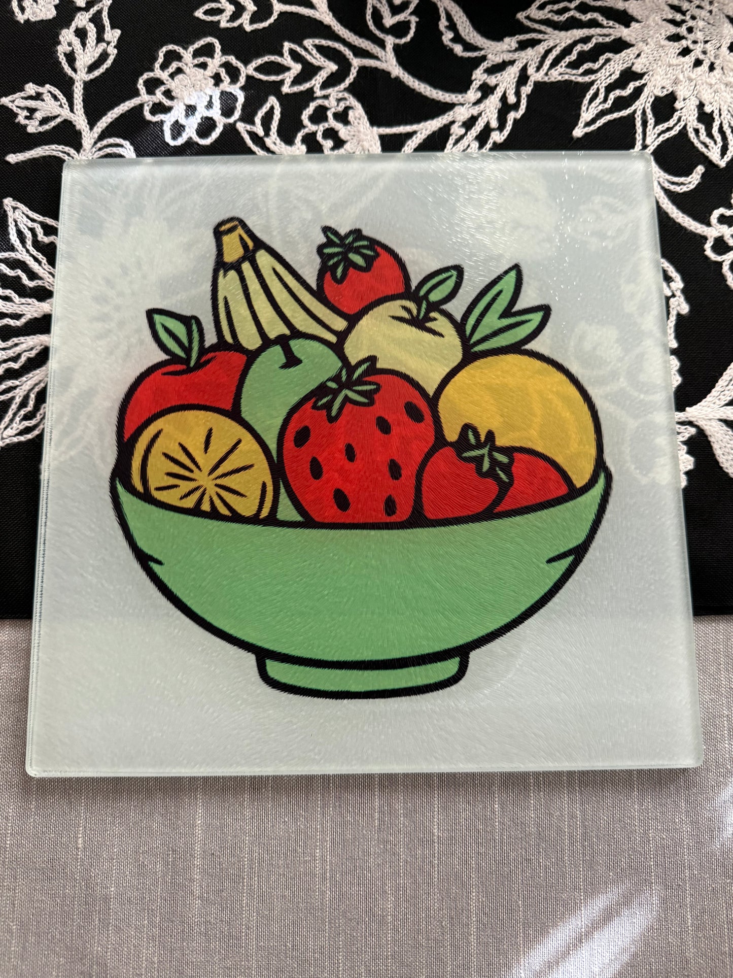 Close-up of the fruit-themed artwork on a decorative glass cutting board, Roxzell