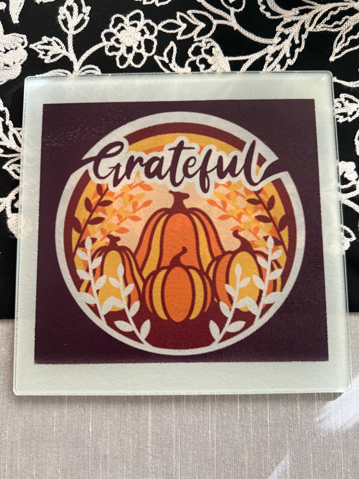 Close-up of maroon glass board with autumn design and white branches