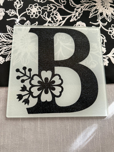 Roxzell personalized glass cutting board with a black letter "B".  The letter "B" has flowers in the design.