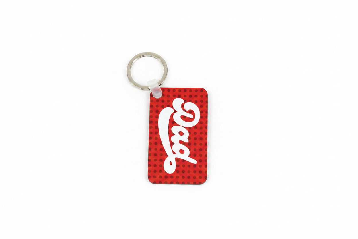 Reverse side of personalized "Anthony" keychain featuring white lettering "Dad" design, on red and black background attached to a silver ring on a white background.