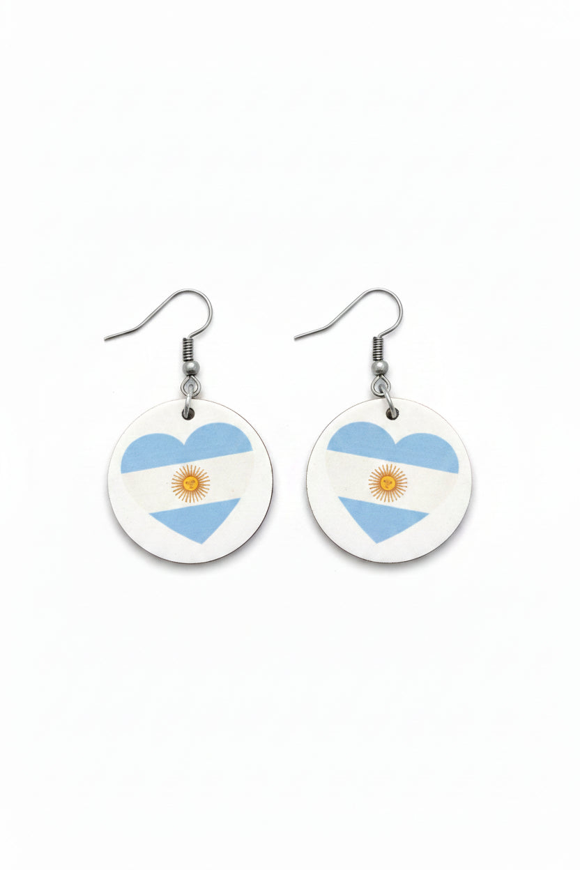 Pair of round earrings with Argentina flag shaped like a heart on a white background. Roxzell
