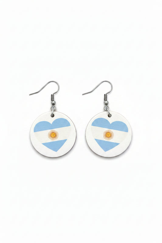 Pair of round earrings with Argentina flag shaped like a heart on a white background. Roxzell