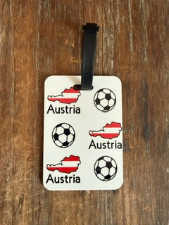 Austria soccer luggage tag with black strap and wooden background. Roxzell