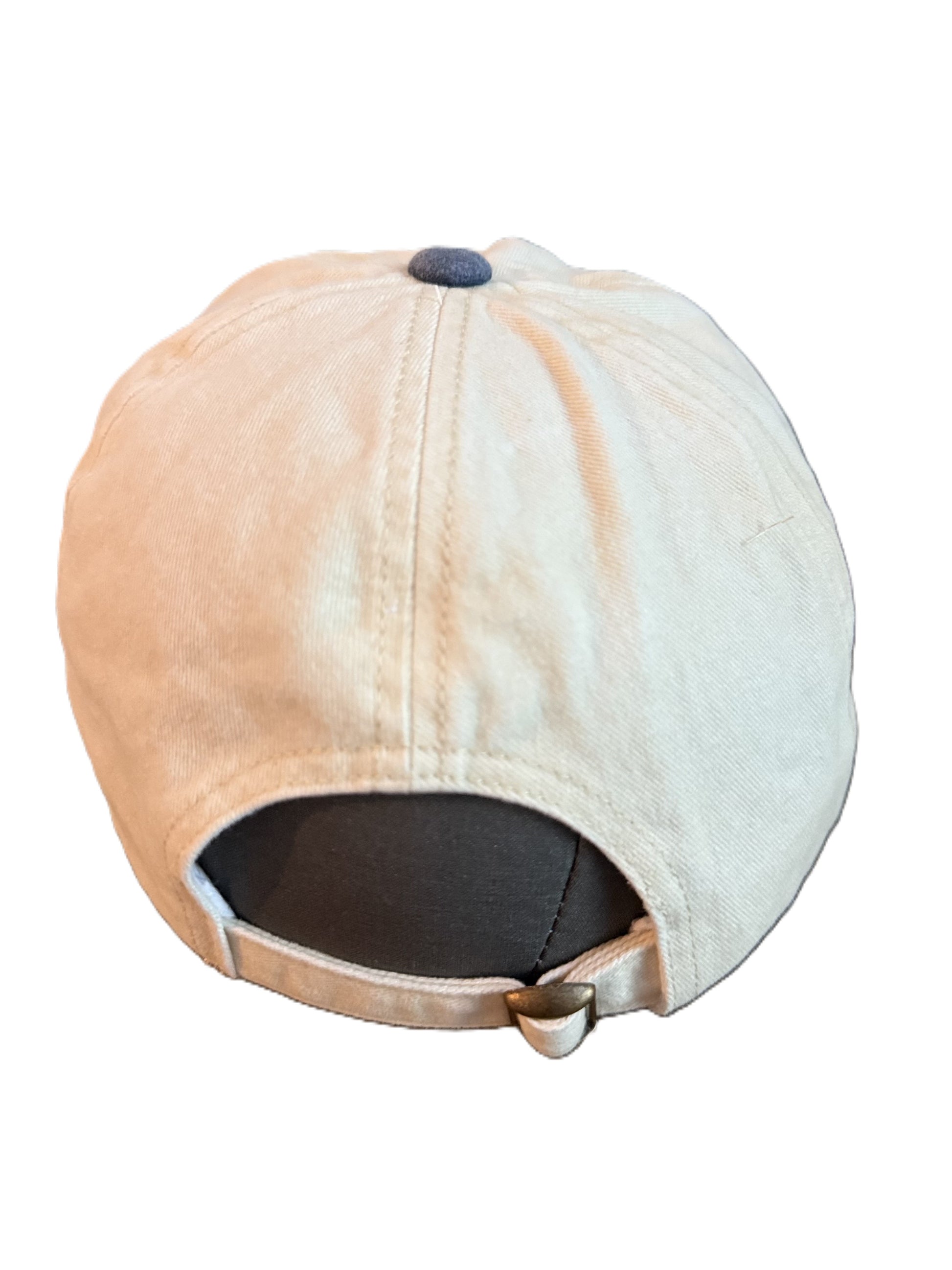 Back view of a beige and denim-blue baseball cap with adjustable strap featuring a metal clasp featuring a circular patch with a bucking horse and the text “Buckin’ Bronco” over red, yellow, and blue stripe. Roxzell