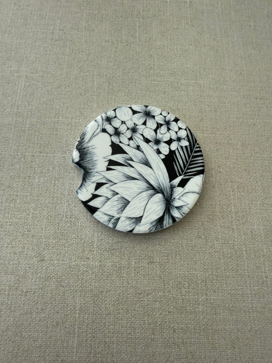 2.5" round ceramic car coaster designed with black and white botanical flowers.