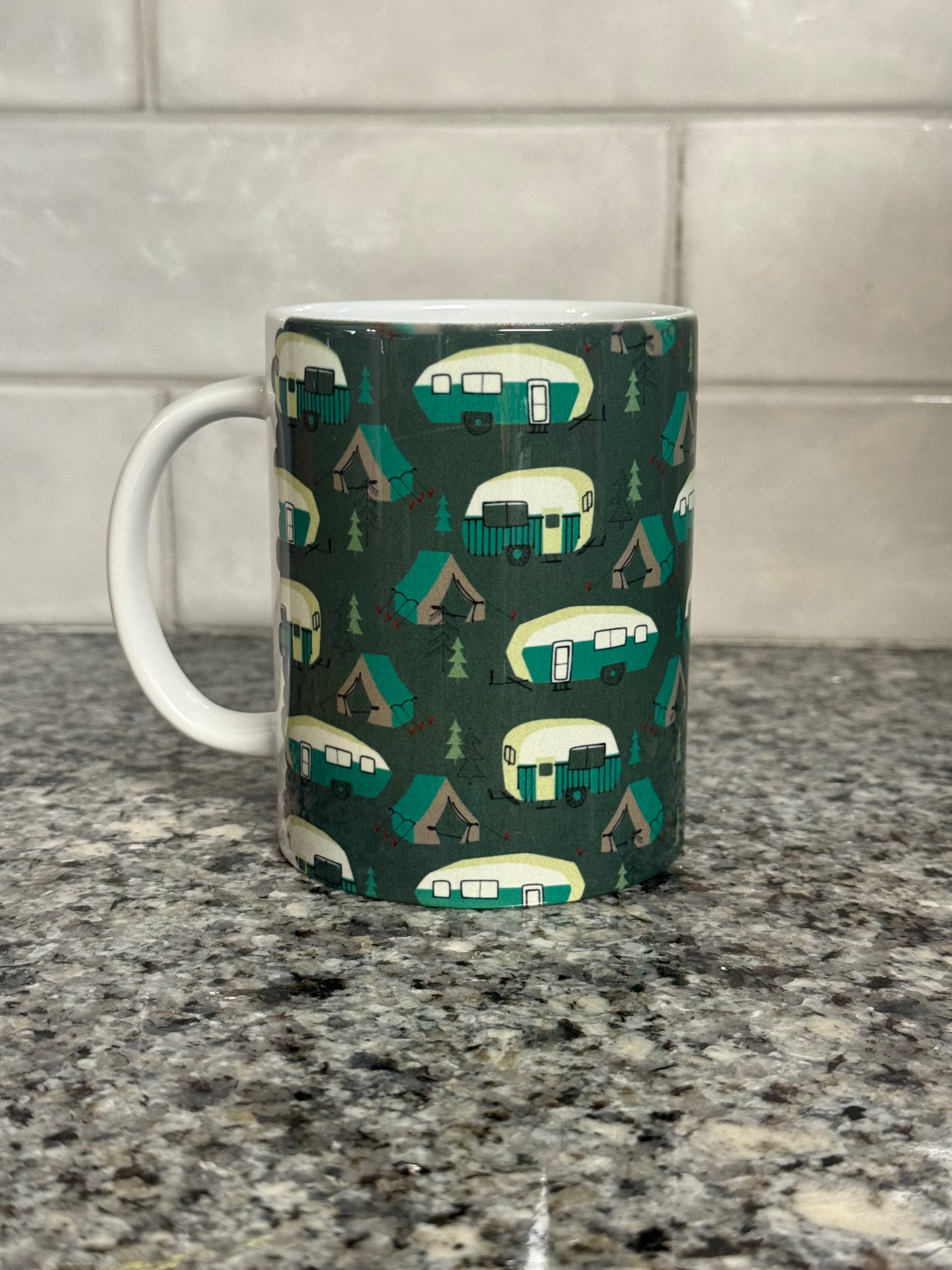 12 oz mug designed with green and white campers, trees, and tents.  Part of our camper series.