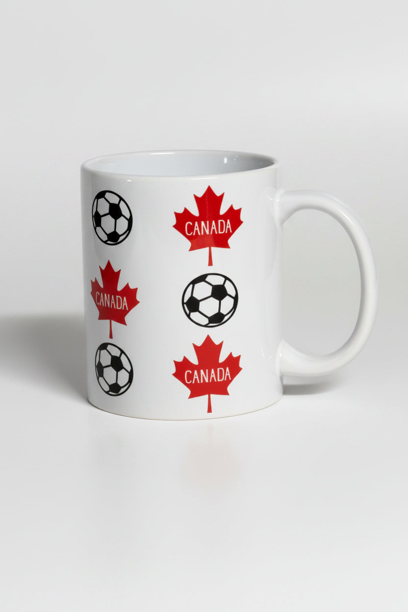 White ceramic mug printed with red maple leaves and soccer balls, representing Canada’s love for the beautiful game.