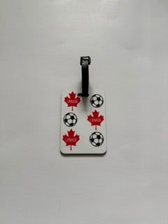 White luggage tag with red maple leaves labeled “Canada” and soccer balls. Roxzell
