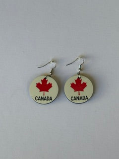 Pair of earrings with 'Canada' and red maple leaf and the word "Canada" in black at the bottom of the earrings design on a white background