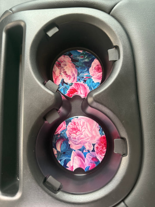 2 car coasters with cabbage rose design in a car cupholder