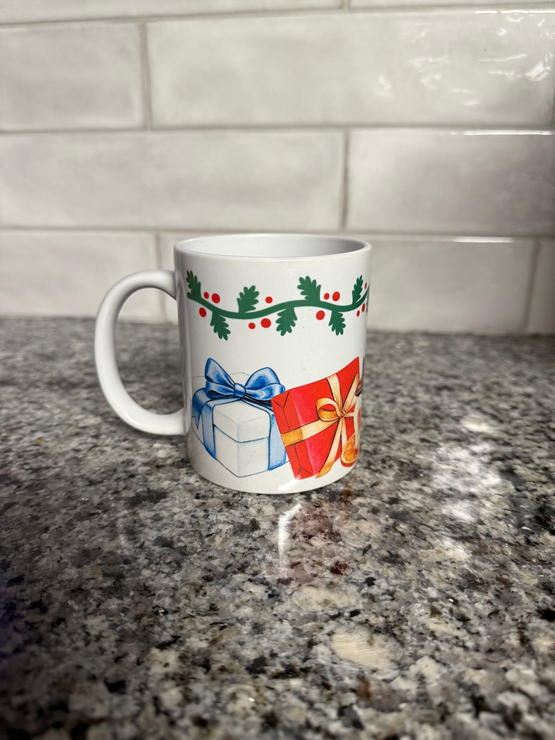 Holiday ceramic mug featuring wrapped presents, dried orange slice, and heart-shaped cookie
