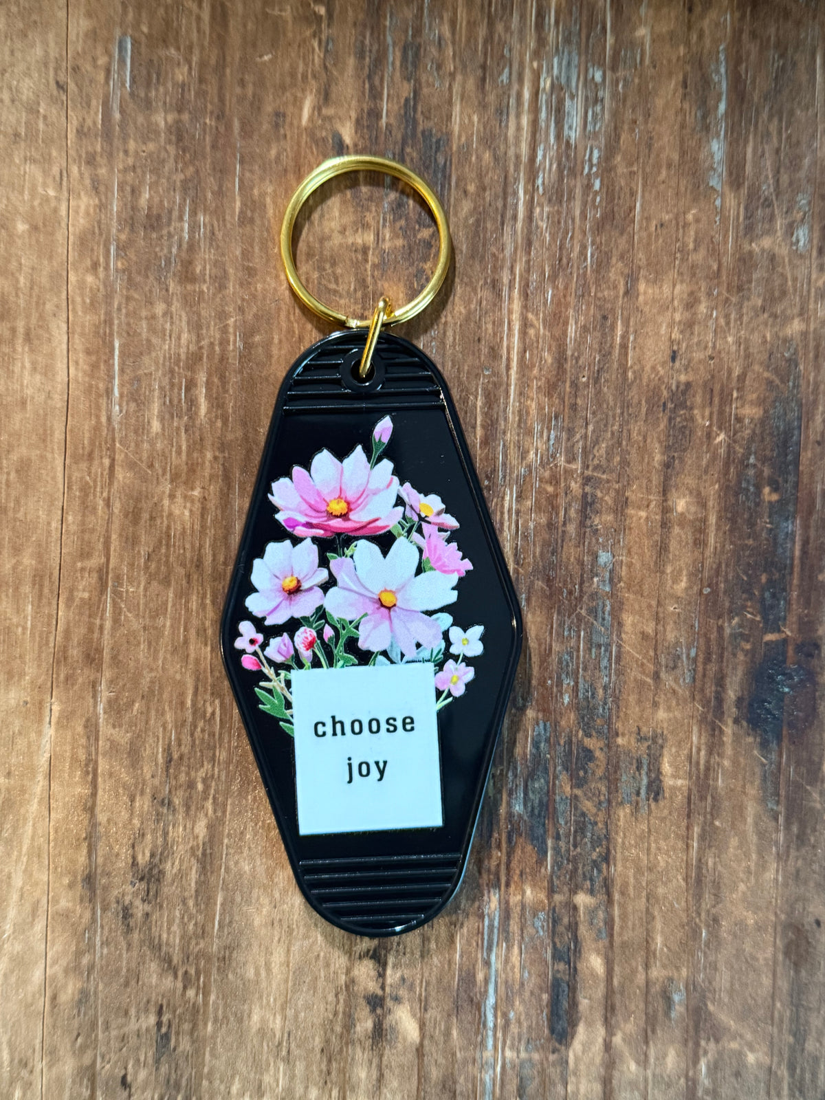 Black Choose Joy motel-style keychain with pink and white flowers. Roxzell