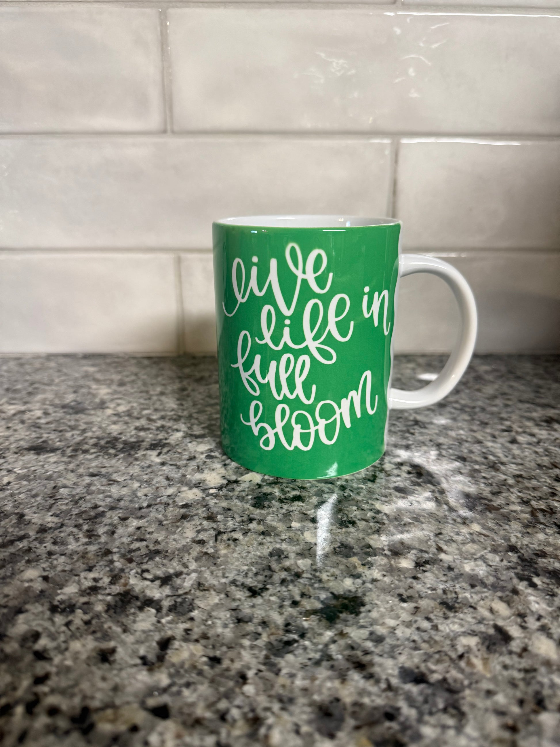 Green ceramic coffee mug with a floral pattern and 'Live Life in Full Bloom' on one side and 'Begin with Kindness' design on the opposite side Roxzell