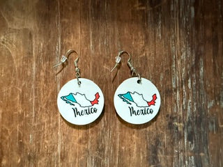 Pair of earrings with 'Mexico' design on a wooden surface
