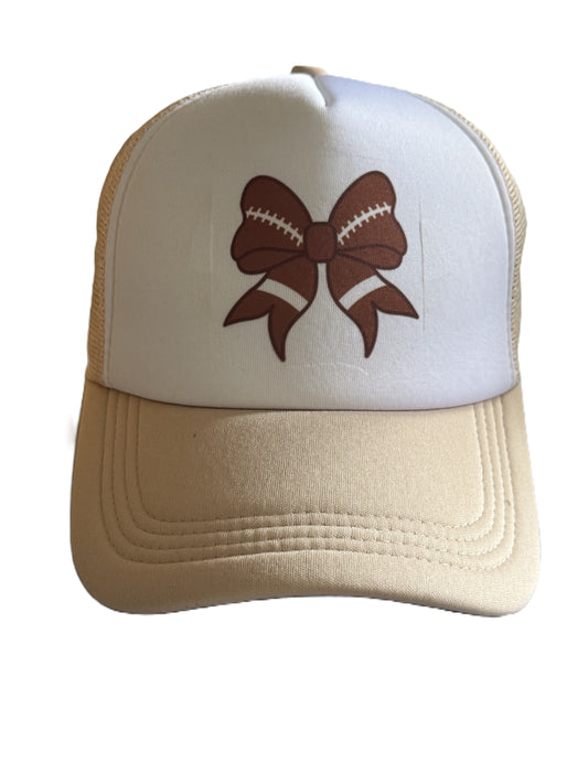 Front view of beige and white trucker hat with brown football‑stitched bow design. Roxzell