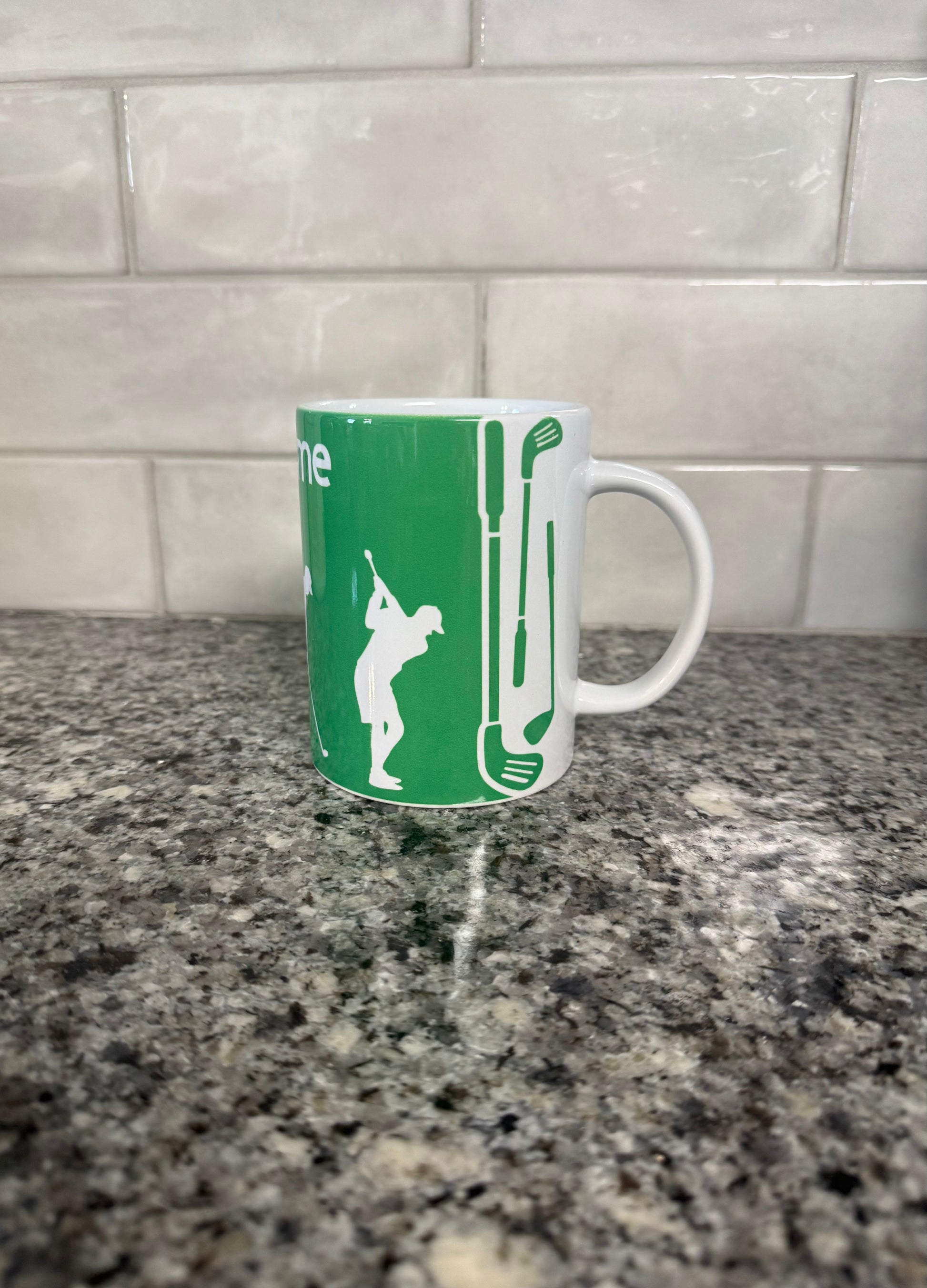 Ceramic mug with golf-themed illustrations, displayed against a kitchen backdrop.