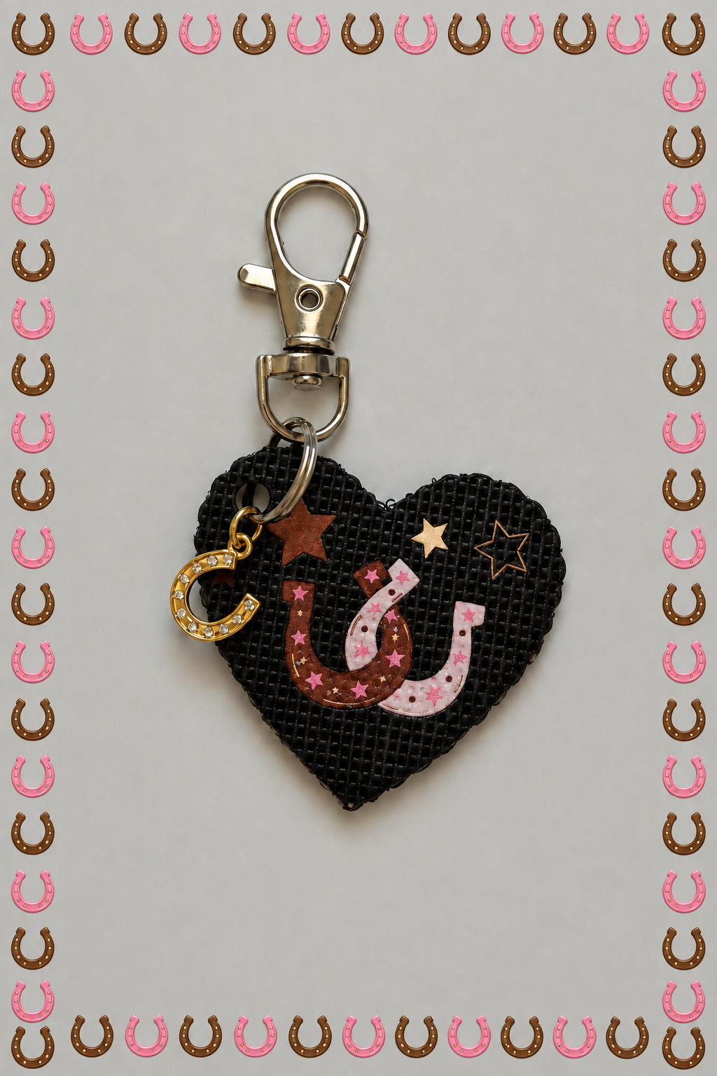 A small black fabric keychain charm with a horseshoe and star design, attached to a gold-tone lobster clasp on a plain light background.
