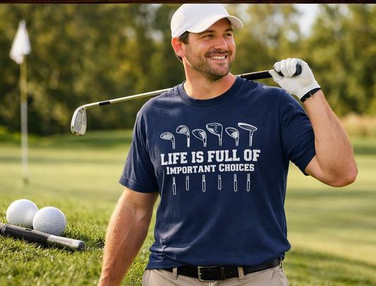 Man on a golf course holding a golf club and wearing a blue t-shirt with a humorous quote, "Life is Full of Important Choices" written between different types of gold clubs. Roxzell