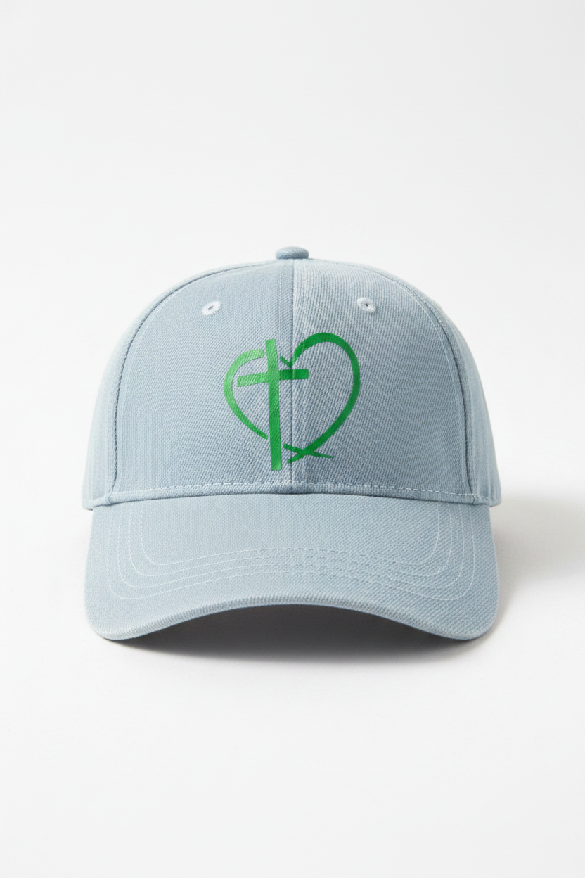 Light blue denim baseball cap with green heart and cross design on front panel