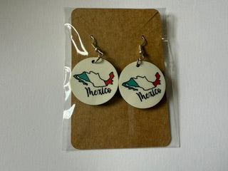 Mexico map earrings attached to a brown backing card inside a clear plastic sleeve, showing green, white, and red map designs with “Mexico” text printed below. Roxzell