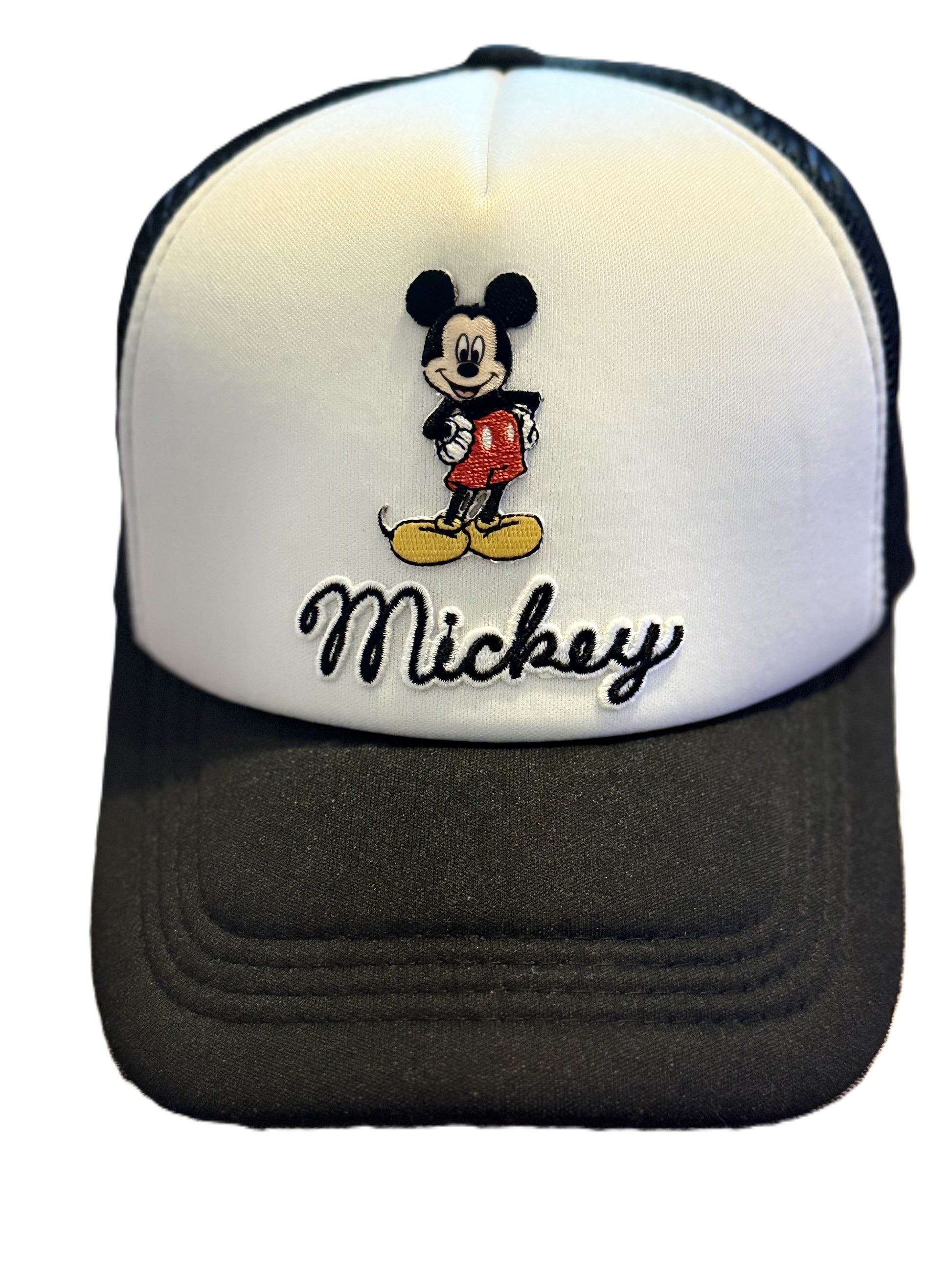 A Mickey Mouse trucker hat with a white front panel, black mesh back, and black brim. The front panel features an embroidered Mickey Mouse graphic above the embroidered black script text 'Mickey'. Roxzell