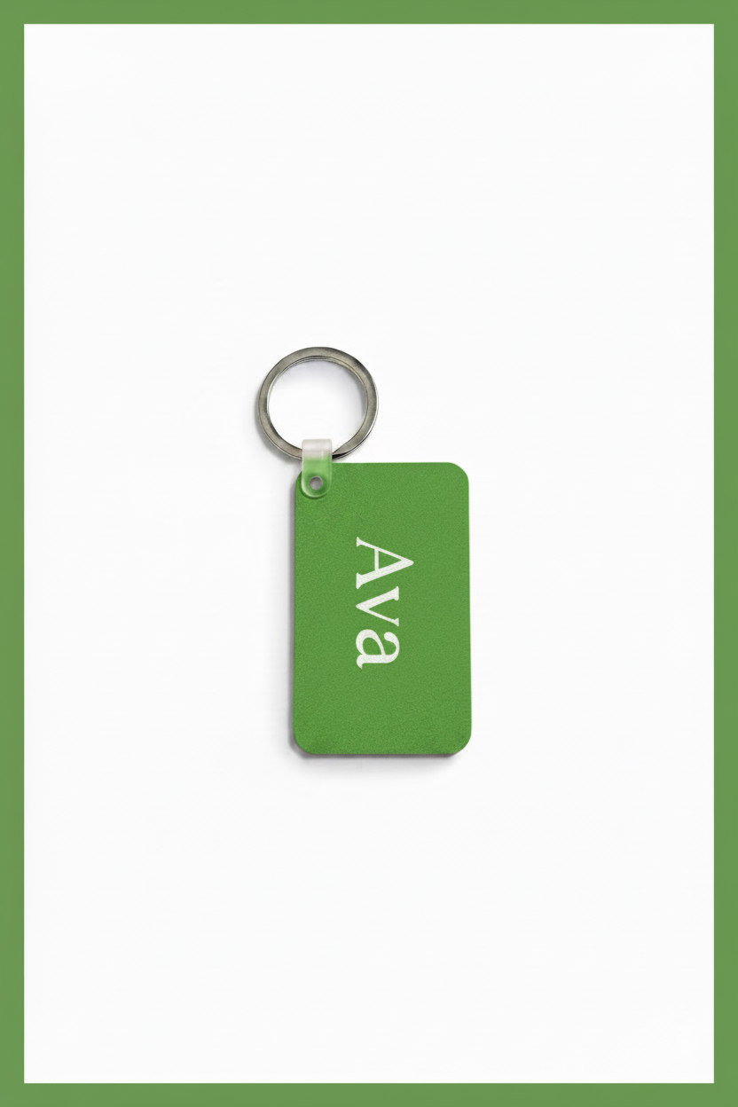 A green rectangular keychain tag with the name 'Ava' printed in white serif lettering, attached to a silver metal key ring, shown on a white background with a green border.
