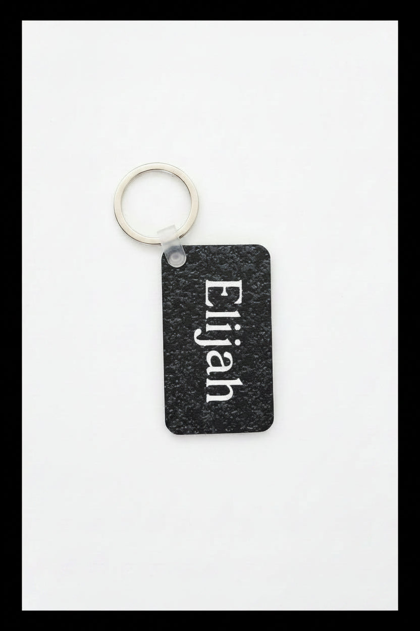 Personalized keychain with name Elijah printed in white 
on a white background with black border. Roxzell