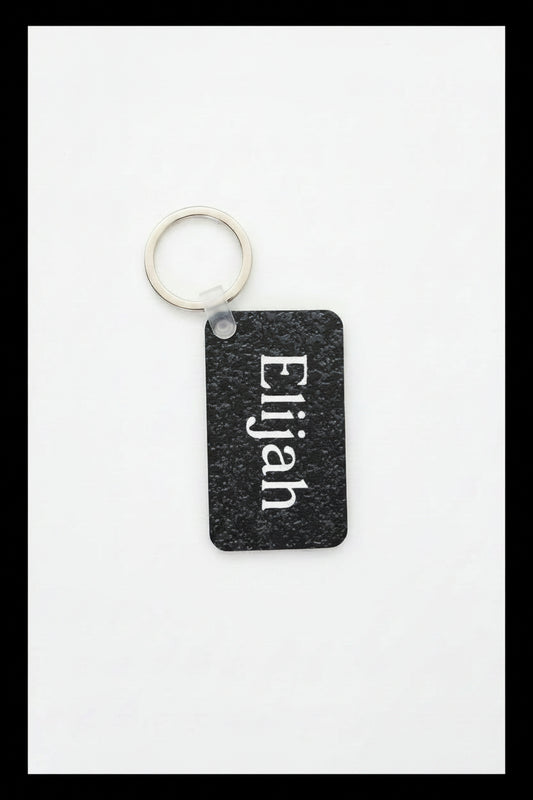 Personalized keychain with name Elijah printed in white 
on a white background with black border. Roxzell