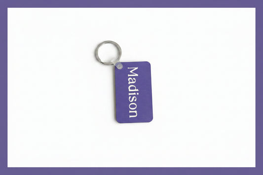 Personalized Madison keychain with white name print on a white background with a purple border. Roxzell