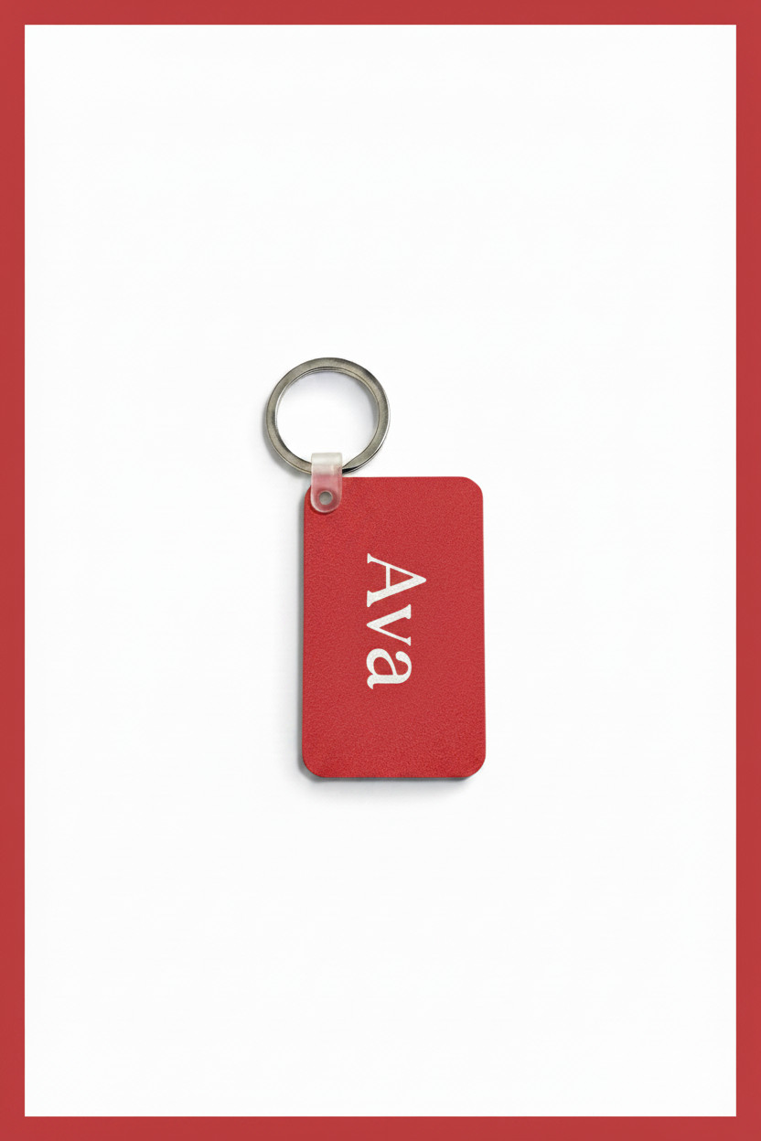 A red rectangular keychain tag with the name 'Ava' printed in white serif lettering, attached to a silver metal key ring, shown on a white background with a red border.