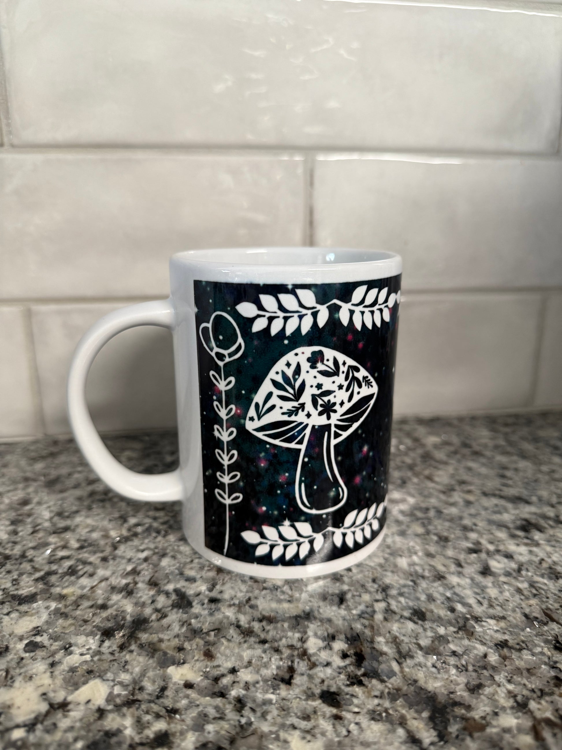 A ceramic coffee mug with mushrooms and flowers design on a black galactic background Roxzell 