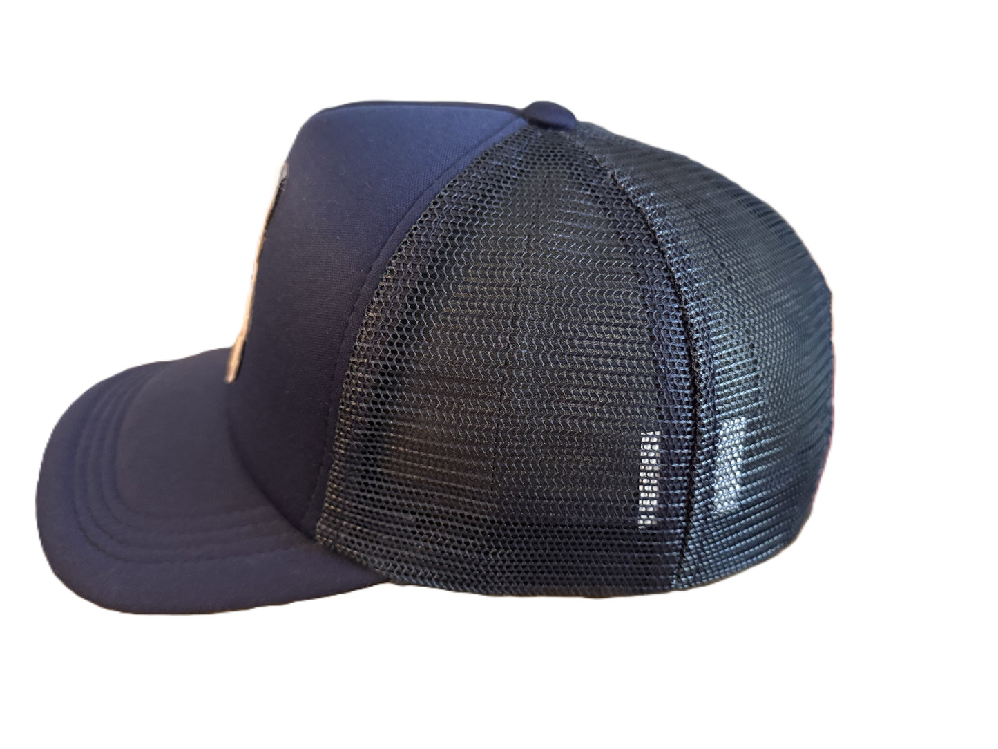 Side view of navy trucker cap showing breathable mesh back and curved brim. Roxzell