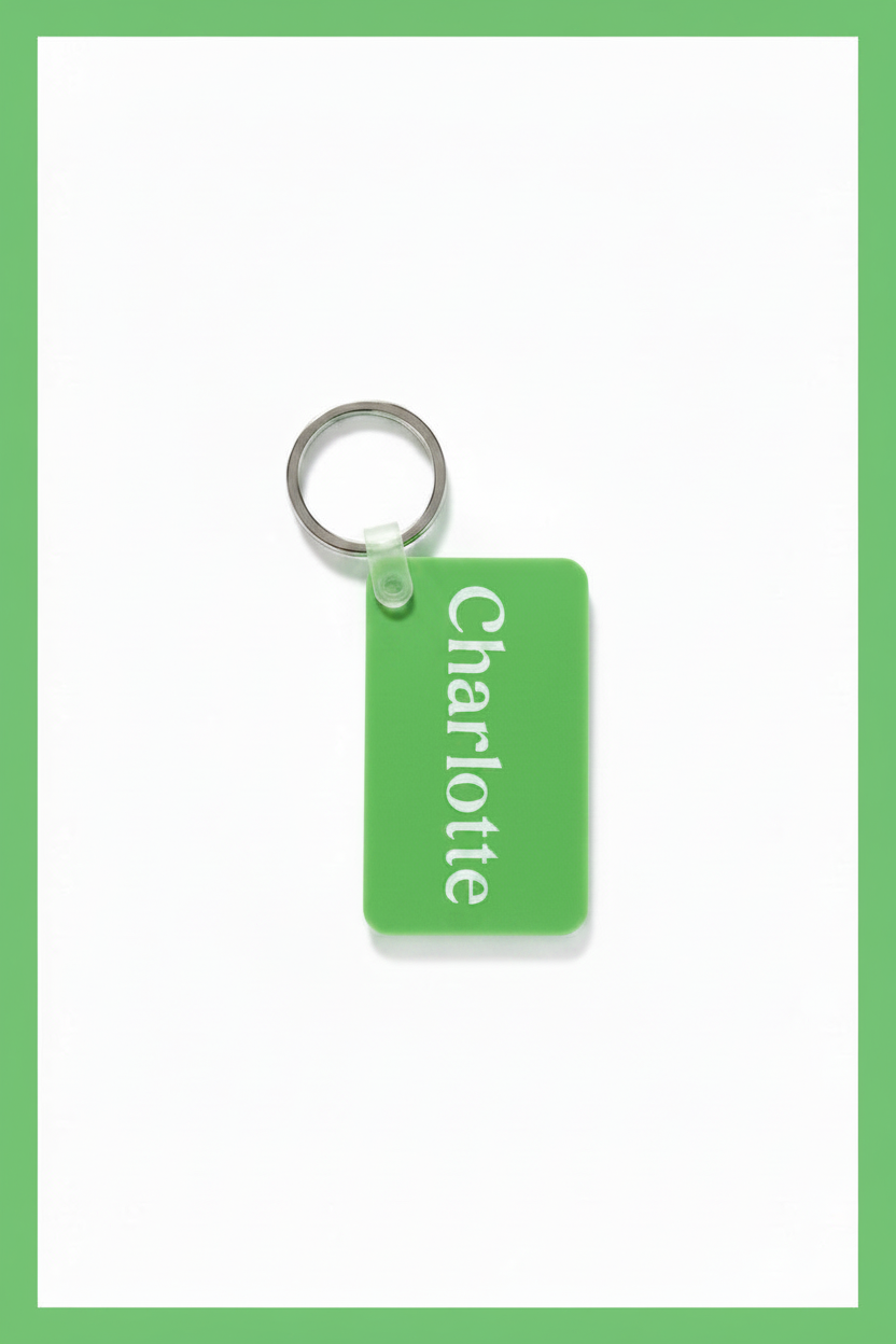 A green rectangular keychain tag with the name 'Charlotte' printed vertically in white, attached to a silver metal key ring on a white background with a green border. Roxzell
