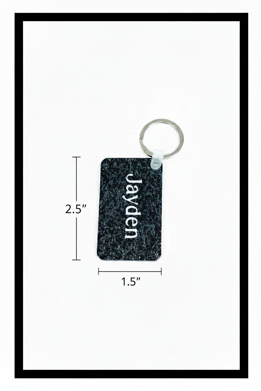 A rectangular black patterned keychain with the name 'Jayden' printed vertically in white, attached to a silver metal key ring, shown on a white background with a black border.
