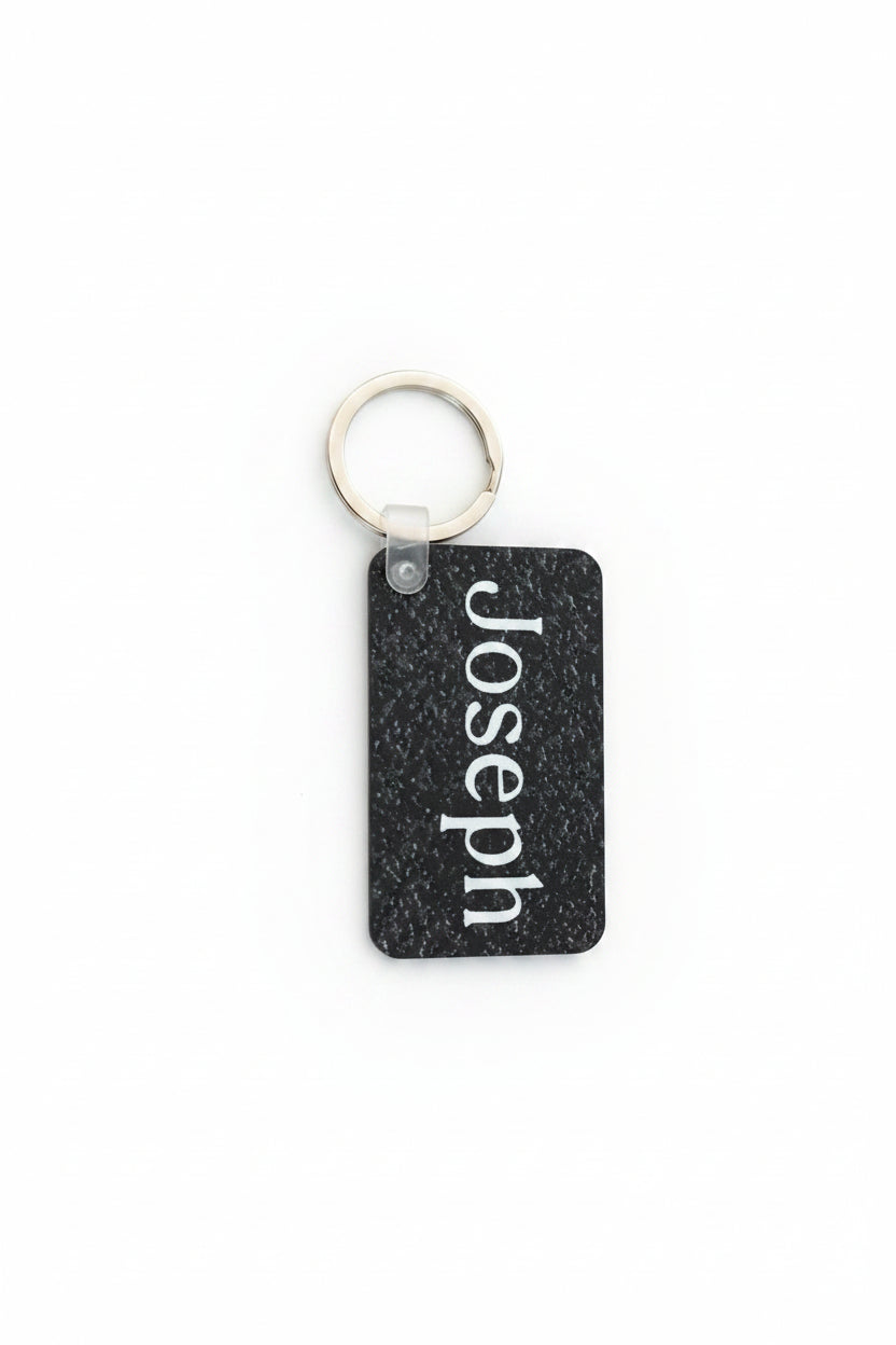 Personalized black speckle keychain with name Joseph in white. Roxzell