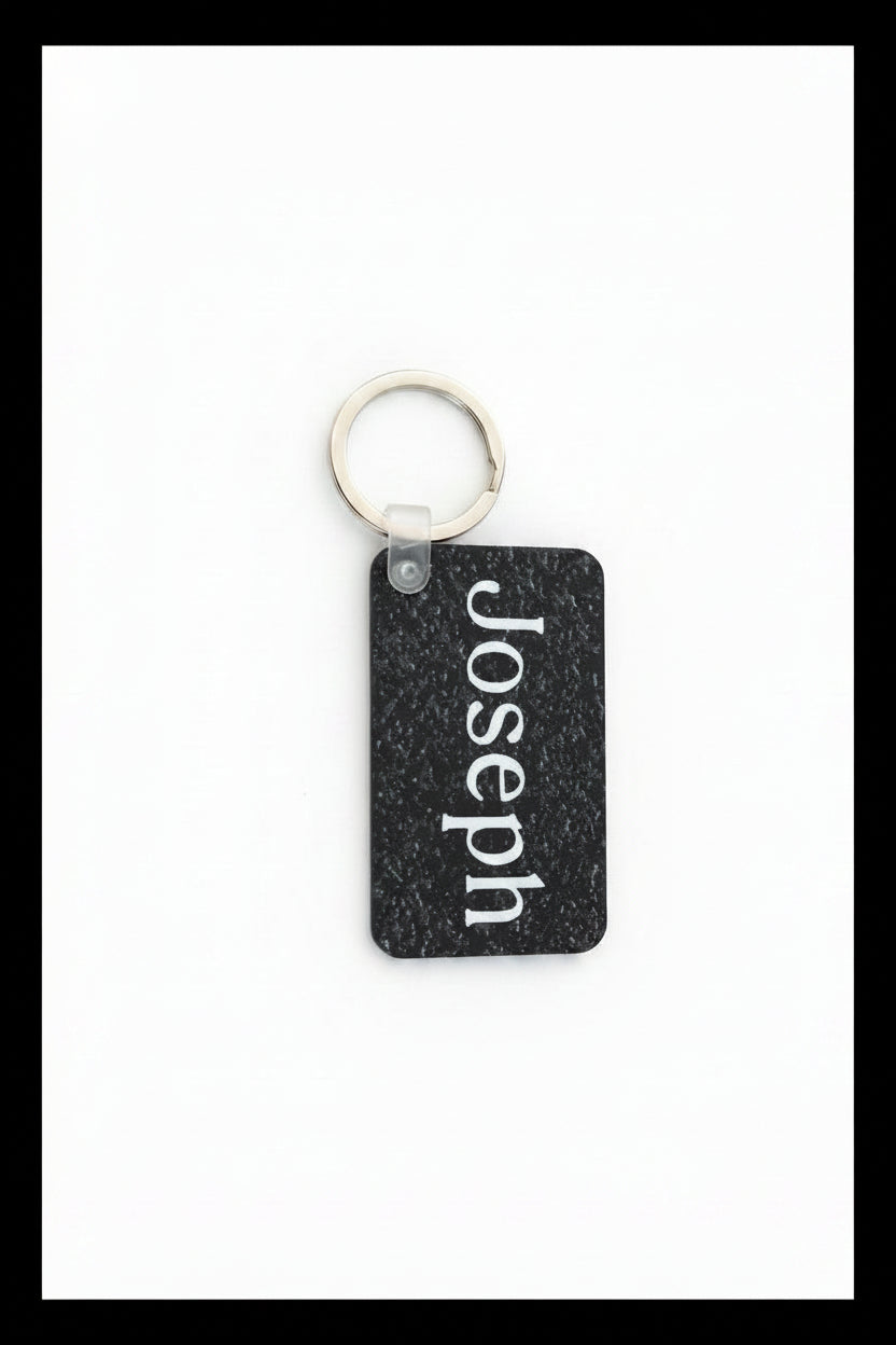 Personalized keychain with name Joseph in white print on a white background with a black border.  Roxzell