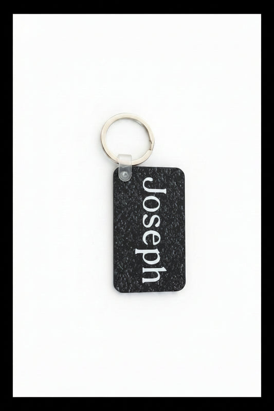 Personalized keychain with name Joseph in white print on a white background with a black border.  Roxzell