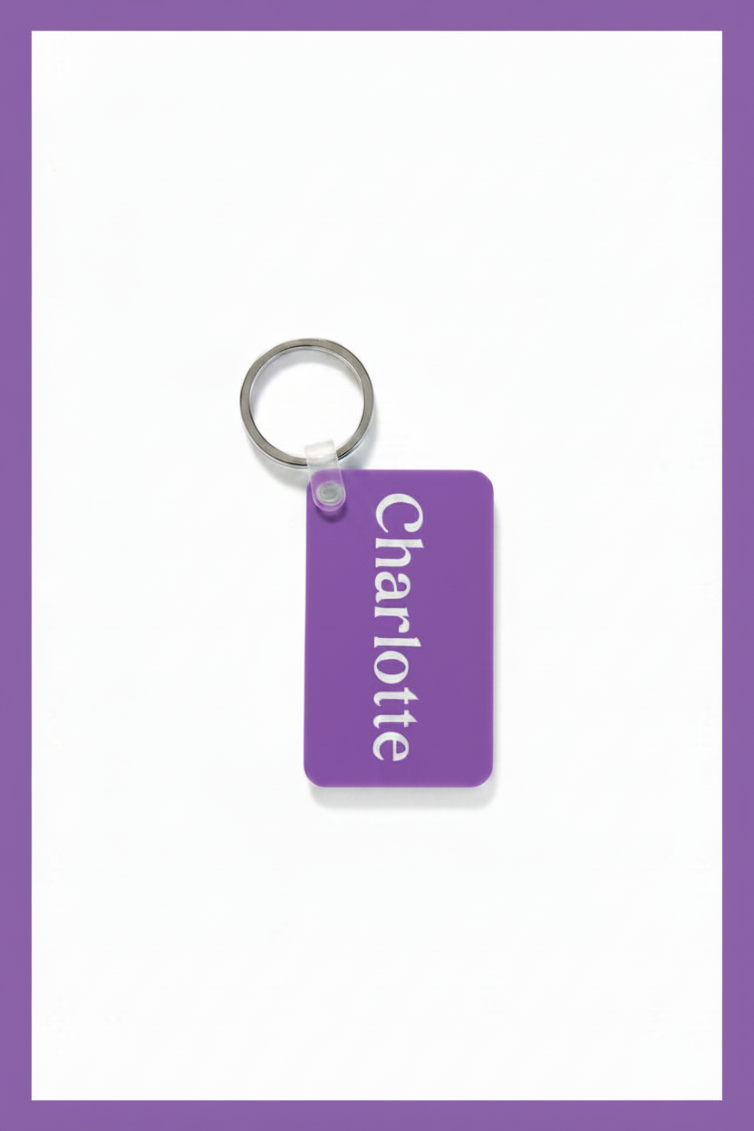 A purple rectangular keychain tag with the name 'Charlotte' printed vertically in white, attached to a silver metal key ring on a white background with a purple border.