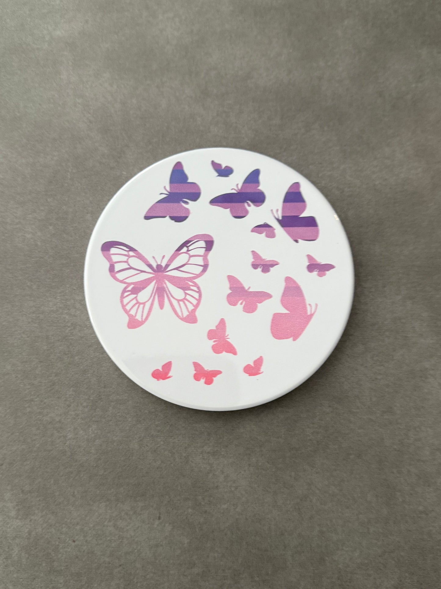 Round ceramic whit coaster designed with pink and purple butterflies.