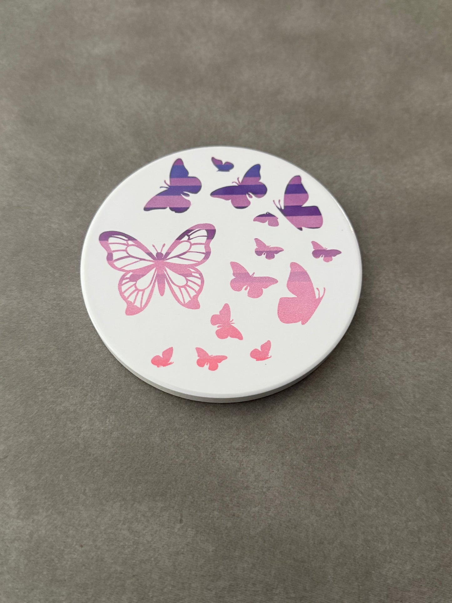Round ceramic whit coaster designed with pink and purple butterflies.