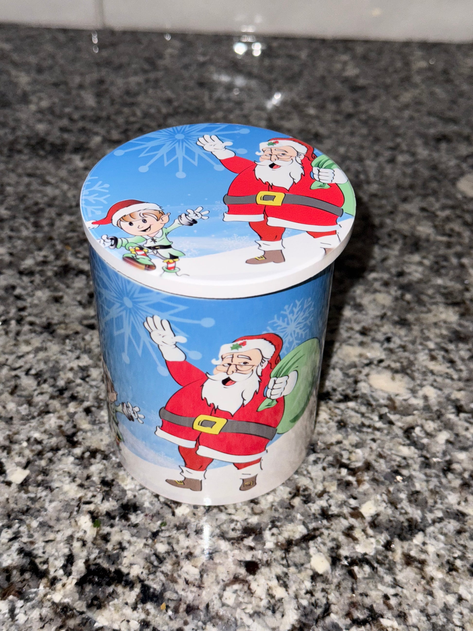 Christmas-themed coffee mug covered with a Santa Claus coaster design on a granite countertop